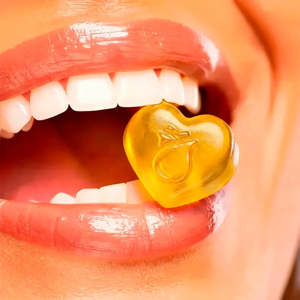 Mujer sonriendo con gomita en forma de corazón para cuidado de cabello, piel y uñas en la boca